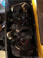 Photo showing black padded chest protector and various black protective gear inside a storage tote.