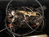 Photo showing a tote filled with various tangled cables, power cords, extension cords in untested condition.