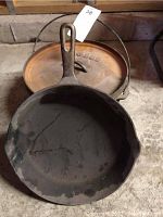 Photo showing the interior of the Wagner fry pan with the Lodge Dutch oven and lid behind it.
