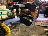 Full view of folding table with items on top and underneath, showing table surface and condition.