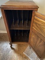 Angled front view of open record cabinet showing internal shelves each with five vertical wooden dividers for organizing vinyl and 78 RPM records.