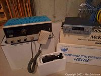 Photo of two vintage CB radios side by side, Lafayette Comstat-25B and McKinley 40 Channel AM/SSB mobile CB radio with handset and box