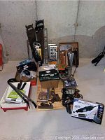 Lot overview showing assorted hand tools, painting tray with rollers, crow bars, saws, and power tool boxes.