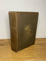 Back and spine angled view showing the thickness and overall wear of the cover. The book's cover is detached but intact as seen