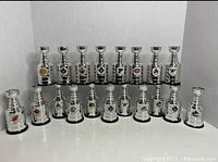 Front view of 19 Labatt’s Blue NHL mini Stanley Cups arranged in two rows showing varying NHL team logos and condition details.
