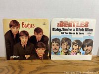 Two Beatles picture sleeve 45 RPM records: 'Love Me Do' and 'Baby, You're A Rich Man'