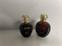 Front view of two vintage Christian Dior Poison Eau De Toilette bottles with red glass and gold-clear caps.