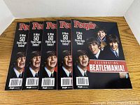 Five People Special magazines displayed fanned out, colorful front covers showing The Beatles smiling and headline 'It Was 50 Years Ago Today!'