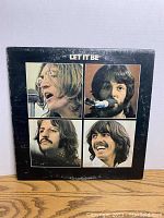 Front cover of The Beatles Let It Be vinyl album showing close-up photos of band members.