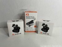 Front view of two boxes of iQ Budz 07 wireless earbuds and one box of iQ Mobile Power car charger, all sealed.