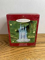 Front view of the Hallmark Keepsake Ornament box showing Cinderella's Castle ornament inside with special lighting effect, branding, and official Disney licensing.