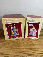 Two boxed Hallmark Keepsake ornaments, one Disney Three Beautiful Princesses and one Barbie The Magic of Pegasus.