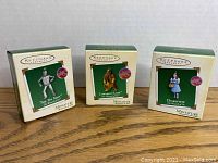Photo showing the three boxed Hallmark Keepsake miniature Wizard of Oz ornaments: The Tin Man, Cowardly Lion, and Dorothy.
