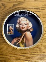 Front of Marilyn Monroe collector's plate showing portrait, signature, and postage stamp image.