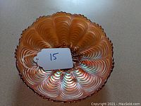 Top view of Fenton marigold carnival glass bowl showing peacock tail pattern and scalloped edges.