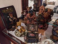 Group photo showing several Boyds Bears resin figurines including one with a 'Bearwear' certificate and bears dressed in different outfits.