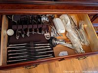 Drawer overview containing flatware set and serving utensils