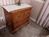Photo of the solid oak dresser showing front view with four drawers and lace cloth on top.
