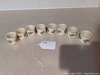 Eight ceramic napkin rings with Spode Christmas Tree pattern arranged in a line showing front detail.