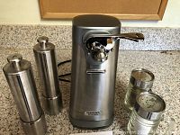 Photo showing Cuisinart electric can opener, two stainless steel grinder shakers, and two glass shaker containers.