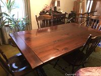 Full view of solid pine dining table with matching chairs around it.