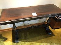 Full view of top and leg base of solid wood trestle table showing dark finish and sturdy build.