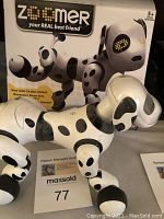 Zoomer robot dog in front of its original box showing branding and toy design.