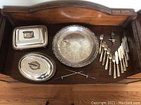 Full view of all items including Birks Regency platter, silver-plated skewers, coat hook, knives, and forks arranged on wooden surface