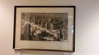 Full front view of framed etching depicting Roman ruins under glass