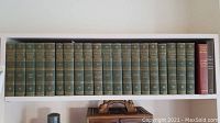 Bookshelf with 18 Harvard Classics volumes in green cloth and 2 additional hardcovers at the end.