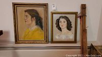Two framed portraits and wooden easel arranged side by side
