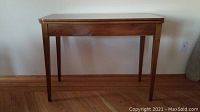 Full front view of table showing rectangular top and four tapered legs.