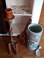 Overview of all lot items: stamps on shelf, ukulele, large candlestick, small candlestick pair, umbrella stand