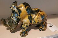 Front and side view of the stone carved rhino statue showing detailed carving and natural multicolor stone pattern.