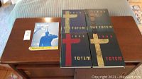 Five hardcover yearbooks on a table including UBC The Totem years and one Ubyssey graduation edition yearbook.