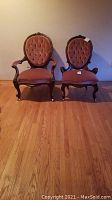 Front view of both Victorian chairs side by side on wooden floor