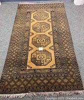 Full view of rectangular rug laid on floor showing overall design, field and borders