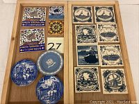 Overview photo showing arrangement of decorative square tiles and small trinket dishes on wooden trays.