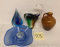 Overview of all four glass pieces: serving dish, teardrop paperweight, elephant figurine, amber bottle