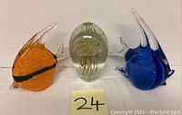 Photo showing three art glass sculptures: orange angelfish, clear jellyfish, and blue angelfish.