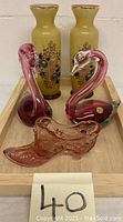 Front view showing all five items: two yellow vases, two pink/red swans, pink lady's shoe