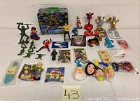 Wide view of all items laid out on a white surface showing the variety of collectible toys and comics.