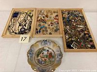Wide view showing three wooden trays filled with costume jewelry and a porcelain bowl in front.