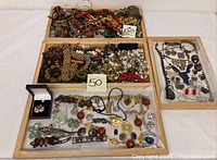 Overview of multiple jewelry pieces arranged in wooden trays