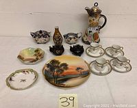 Overall view of the Japanese porcelain lot including coffee pot, teapots, cups, creamer, sugar bowl, plates, and small vase.