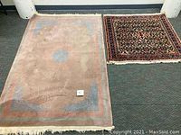 Two scatter rugs laid on floor, showing overall condition and design contrast between beige medallion rug and darker floral Hamadan rug