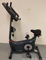 Side view of the upright bike showing frame, pedals, seat and handlebars