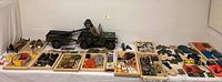 Wide overview of jeep towing trailer with figure, spotlight and trays of accessories