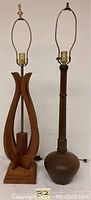 Photo of two vintage wood lamps side by side showing full height and base design