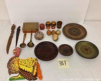 Full lot of assorted wood decor items including plates, vanity box, lacquered spoons and cups, decorative eggs, and Thanksgiving tissue holder